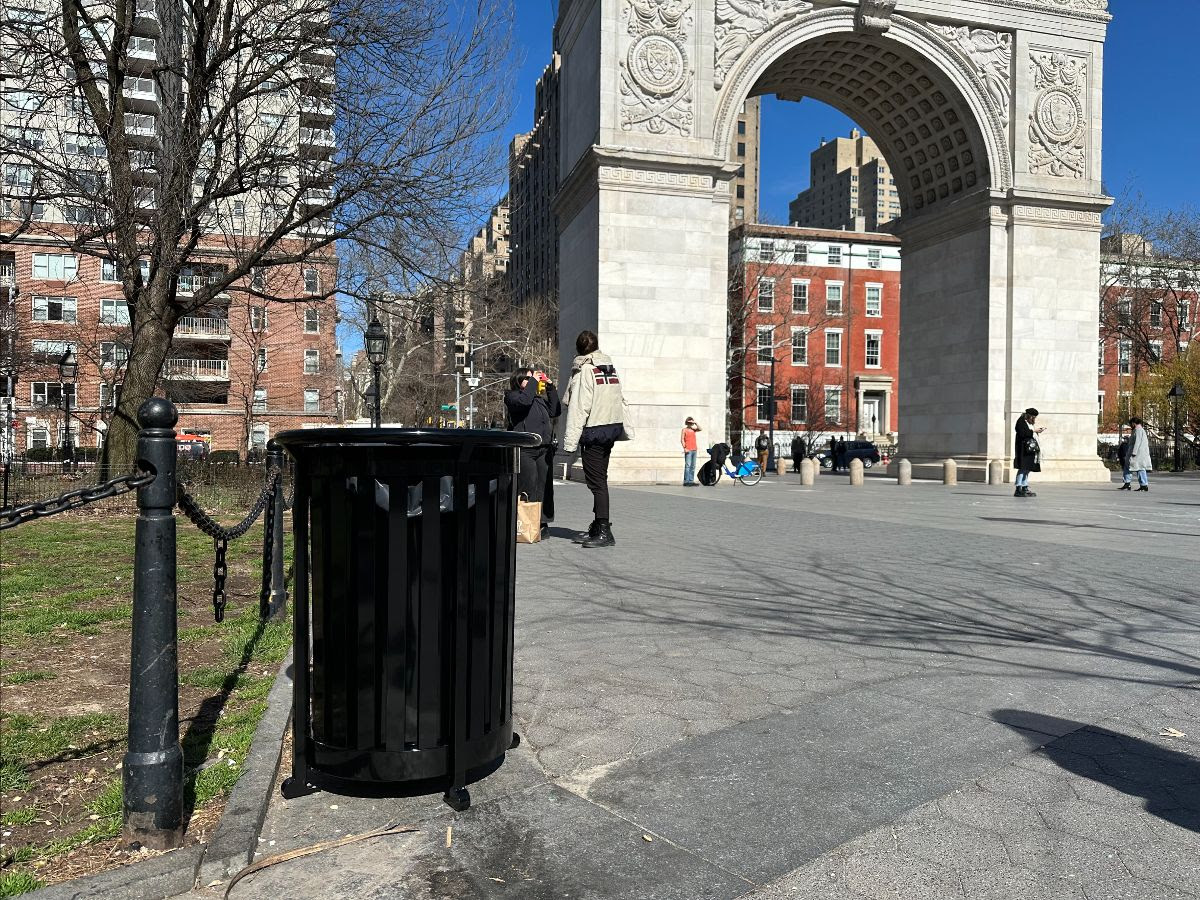 Black trash can with Washington Square Park Arch in the background