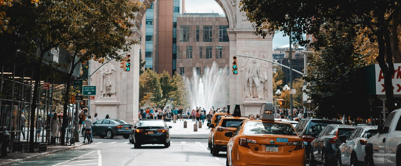 Photo of street and washington square park arch, with trees